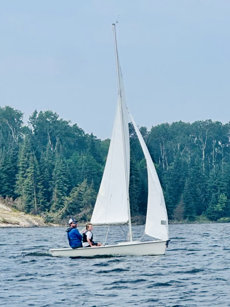 A sailboat with a father and son sailing in a river