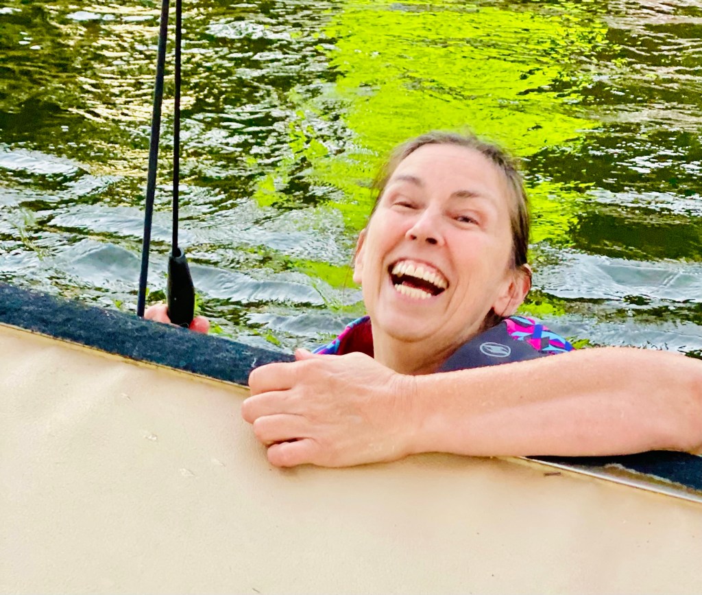 A woman smiling and laughing while in the water